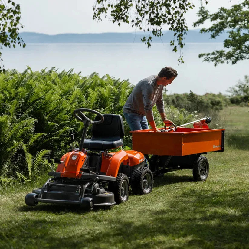 Husqvarna frontzitmaaier met aanhangwagen op een groot gazon